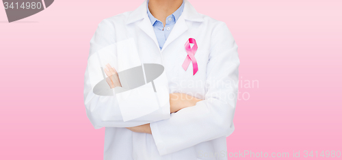 Image of smiling female doctor with cancer awareness ribbon