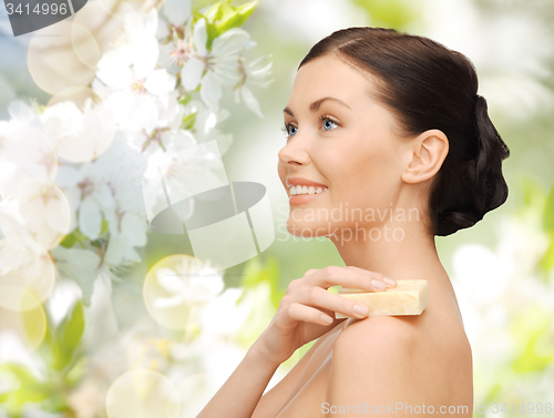 Image of woman with soap bar over cherry blossom background