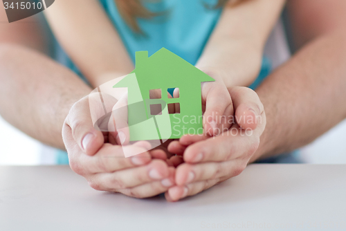 Image of close up of man and girl hands with paper house