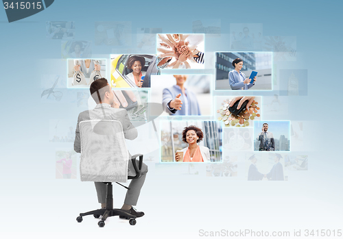 Image of businessman sitting in office chair from back