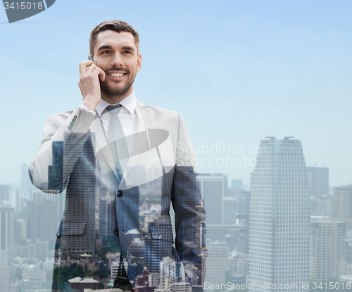 Image of smiling businessman with smartphone in city