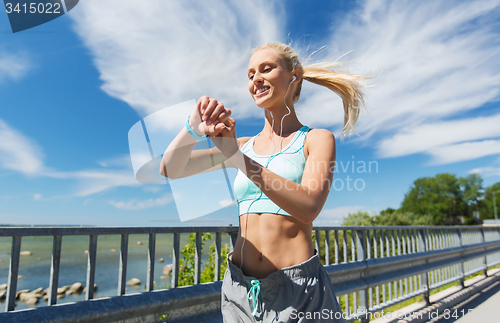 Image of happy woman with heart rate watch and earphones