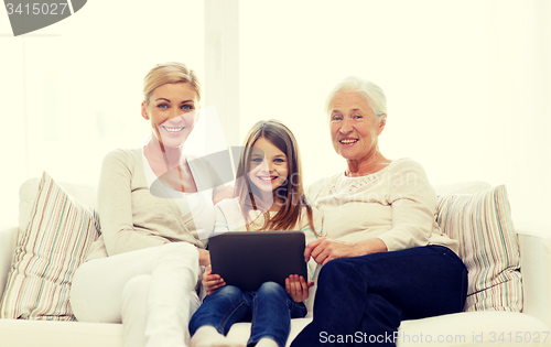 Image of smiling family with tablet pc at home