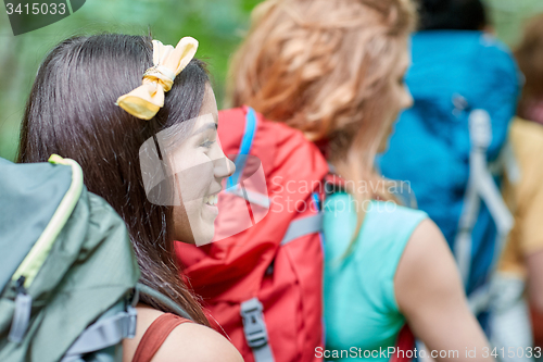 Image of group of smiling friends with backpacks hiking