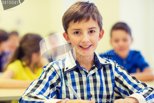 Image of group of school kids writing test in classroom