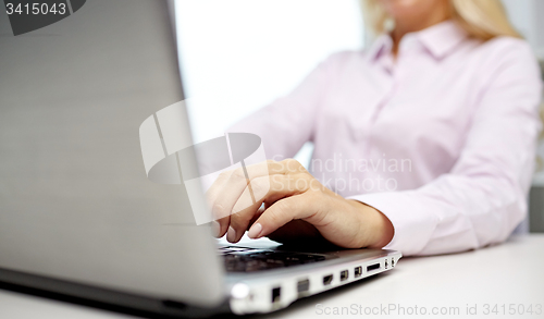 Image of smiling businesswoman or student typing on laptop