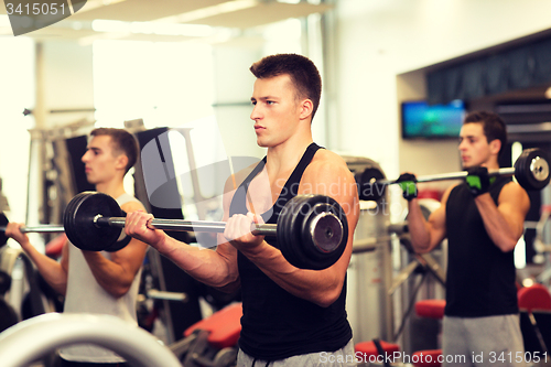 Image of group of men with barbells in gym