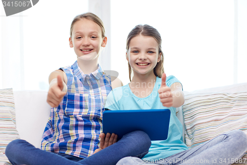 Image of happy girls with tablet pc and showing thumbs up