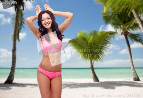 Image of happy young woman in pink bikini swimsuit on beach