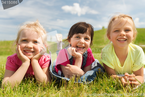 Image of group of kids lying on blanket or cover outdoors