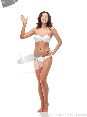 Image of happy young woman in white swimsuit waving hand
