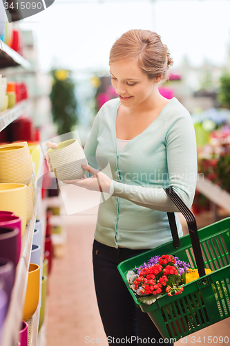 Image of woman with shopping basket choosing flowerpot