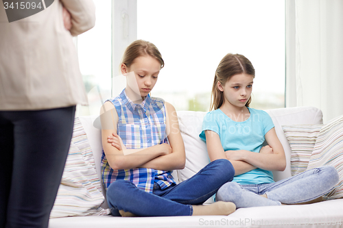 Image of upset guilty little girls sitting on sofa at home