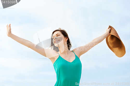 Image of girl in hat standing on the beach