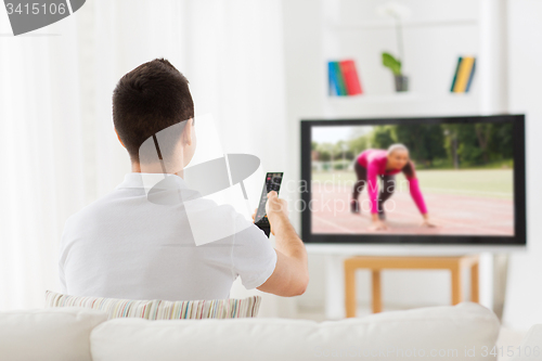 Image of man watching sport channel on tv at home