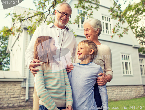 Image of happy family in front of house outdoors