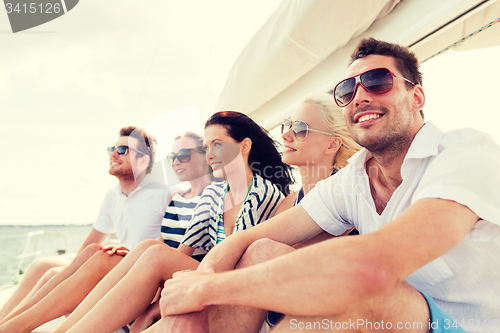 Image of smiling friends sitting on yacht deck