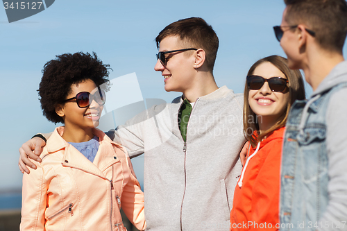 Image of happy teenage friends in shades talking on street