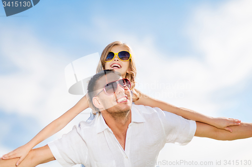 Image of happy father and child in sunglasses over blue sky