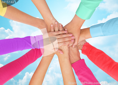 Image of close up of women hands on top in rainbow clothes