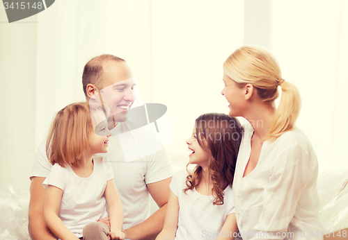 Image of smiling family with two little girls at home