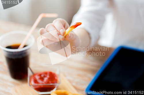 Image of close up of woman hand holding french fries