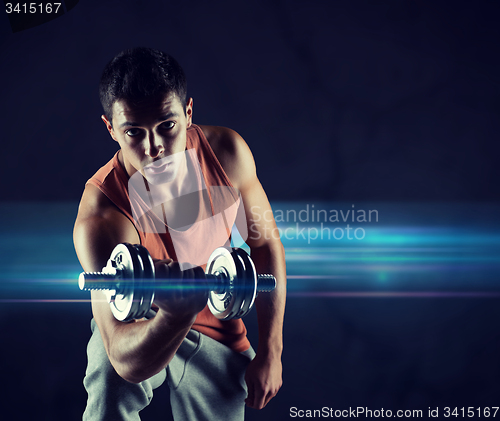 Image of young man with dumbbell flexing biceps