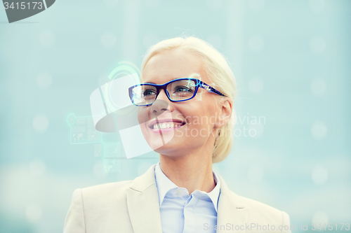 Image of young smiling businesswoman in eyeglasses outdoors