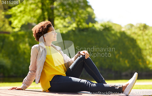 Image of happy african american young woman in summer park