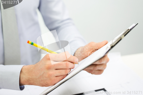 Image of close up of businessman hands with clipboard