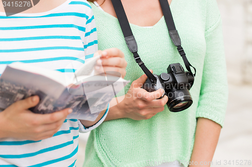 Image of close up of women with city guide and camera