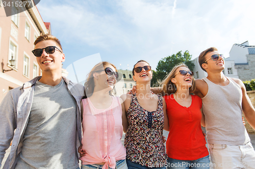 Image of group of smiling friends walking in city