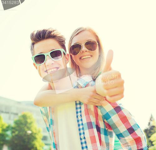 Image of smiling couple having fun and showing thumbs up