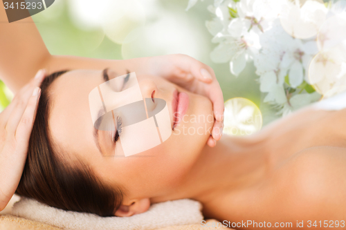 Image of beautiful woman in spa salon having facial massage