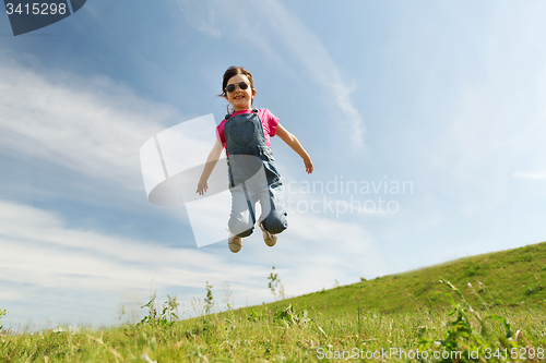 Image of happy little girl jumping high outdoors