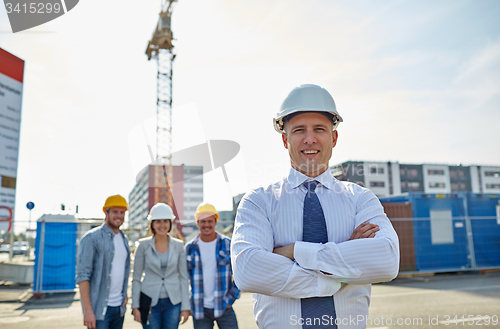 Image of happy builders and architect at construction site