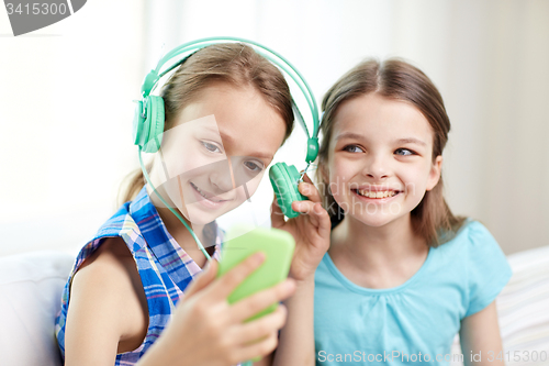 Image of happy girls with smartphone and headphones