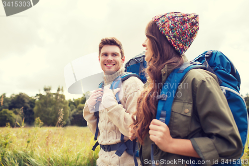 Image of smiling couple with backpacks hiking