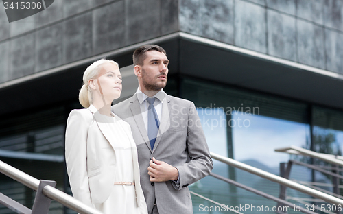 Image of serious businessmen standing over office building