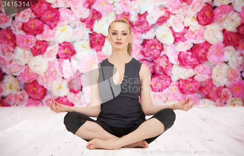 Image of happy young woman meditating in yoga lotus pose
