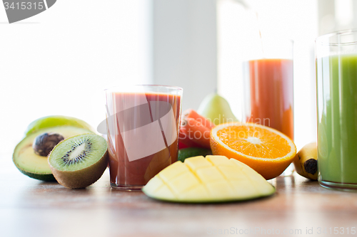 Image of close up of fresh juice glass and fruits on table