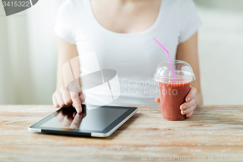 Image of close up of woman with tablet pc and smoothie