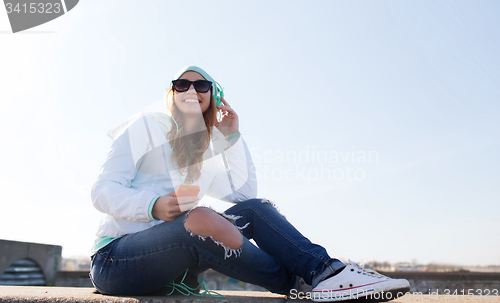 Image of happy young woman with smartphone and headphones