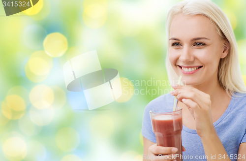 Image of smiling woman drinking juice or shake