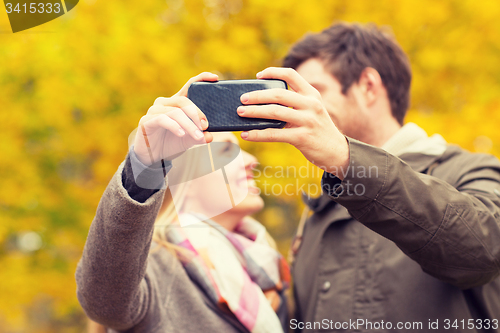 Image of couple taking selfie with smartphone in park