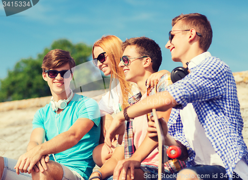 Image of group of smiling friends sitting on city street