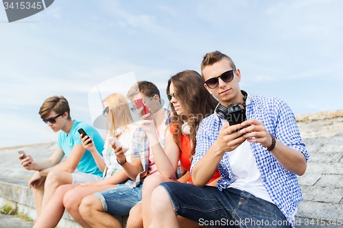 Image of group of friends with smartphone outdoors