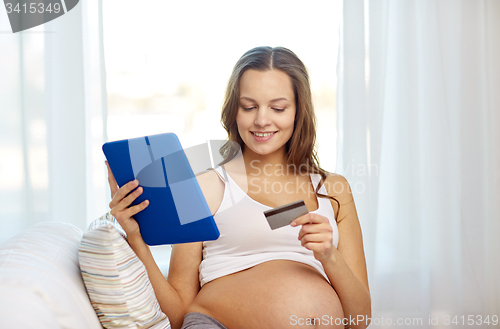 Image of pregnant woman with tablet pc and credit card