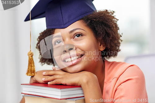 Image of happy african bachelor girl with books at home