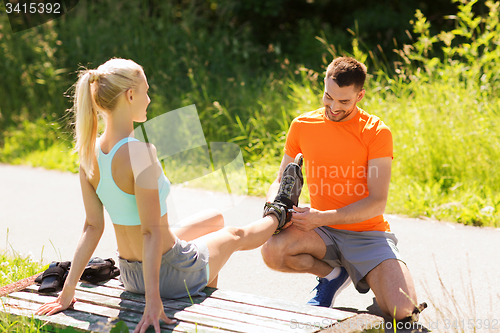 Image of happy couple with roller skates outdoors